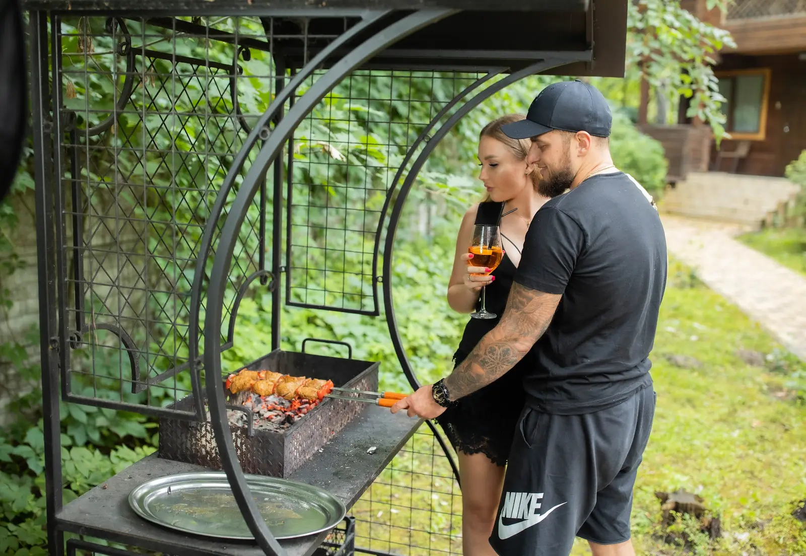 A couple grilling kebabs by a Villa Vita cottage