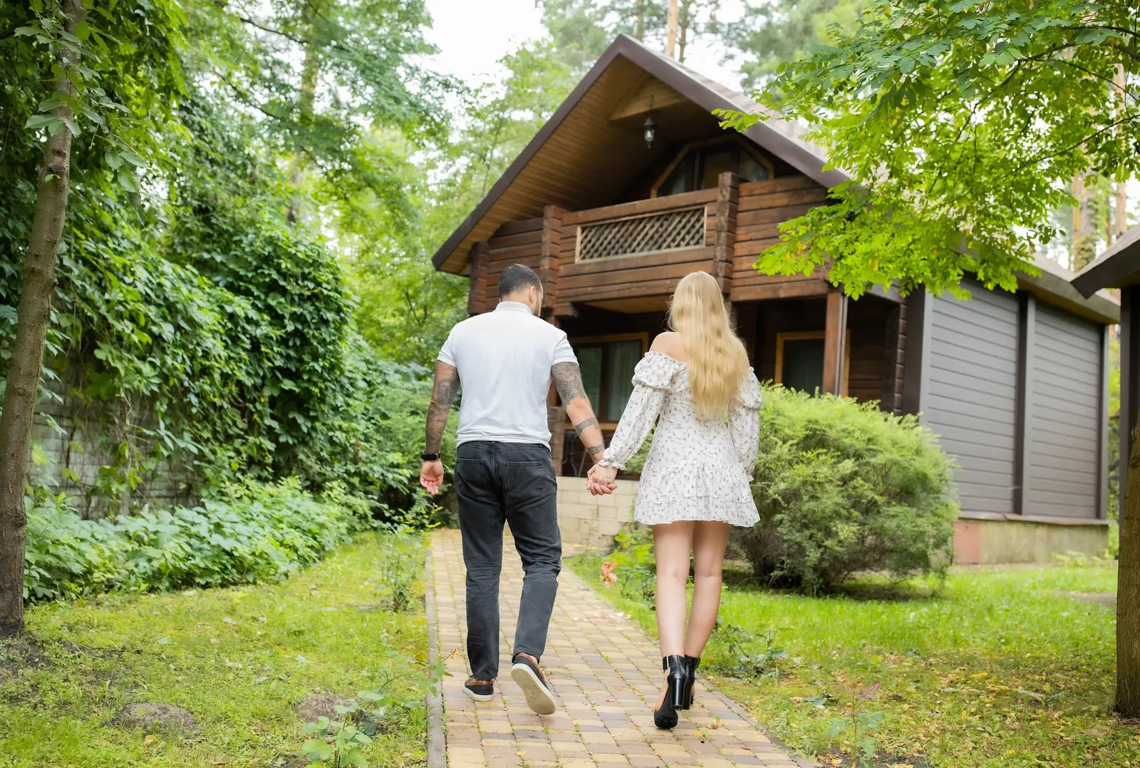 A couple walking to their cottage among the greenery of Villa Vita