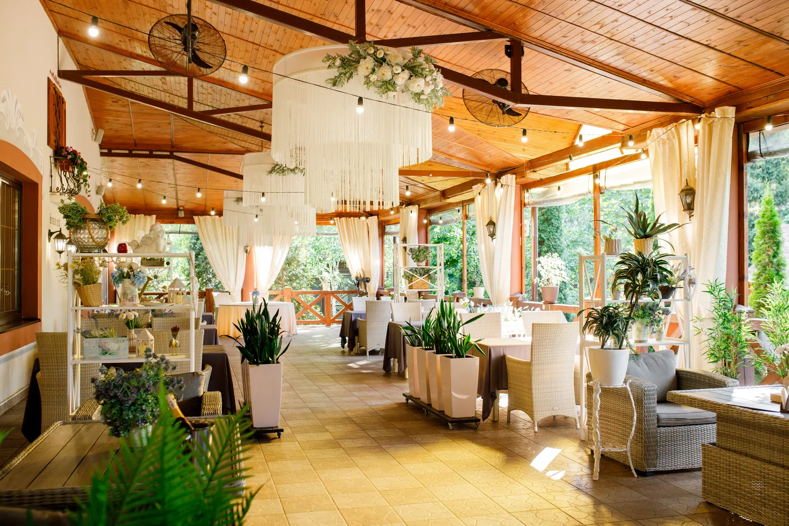 Летняя терраса ресторана Villa Vita с люстрами и цветами